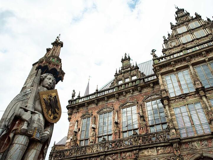 Ein Blick auf den Roland (l) neben dem Alten Rathaus in Bremen.
