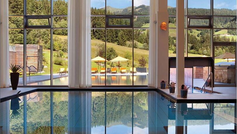 Ein Blick aus dem beheizten Innenpool des Kempinski Hotels "Das Tirol" ins Freie, wo sich die Wasserlandschaft fortsetzt.