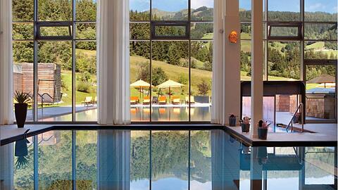 Ein Blick aus dem beheizten Innenpool des Kempinski Hotels "Das Tirol" ins Freie, wo sich die Wasserlandschaft fortsetzt.