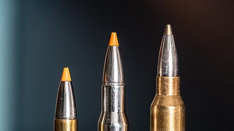 Jagdpatronen im Kaliber 308 Winchester (l-r), 30-06 Springfield und 300 Winchester Magnum stehen bei einem Jäger auf einem Waffenschrank. (Symbolbild)
