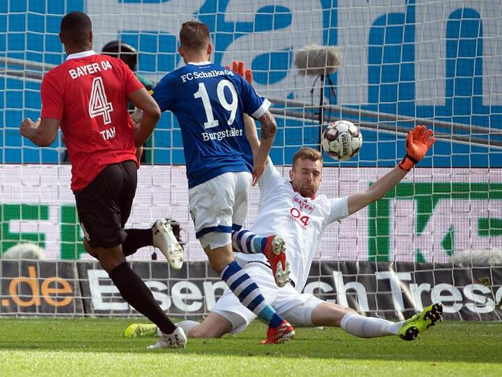 Leverkusens Torwart Lukas Hradecky (r) kann das 1:1 durch Schalkes Guido Burgstaller (M) nicht verhindern.