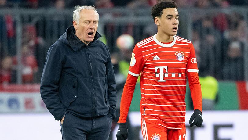 Trainer Christian Streich (l) von Freiburg und Jamal Musiala von München stehen nach dem Spiel zusammen.
