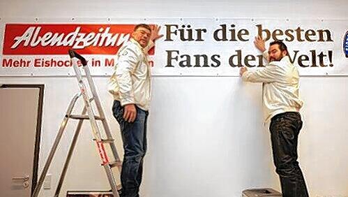 Sie wollen hoch hinaus und mussten hoch hinauf: Trainer Pat Cortina (li.) und Manager Christian Winkler hängen das EHC-Banner „Für die besten Fans der Welt“, mit dem die Abendzeitung und der EHC gemeinsam den EHC-Anhängern huldigen, im Büro des AZ-Sportchefs auf. Sie wollen hoch hinaus und mussten hoch hinauf: Trainer Pat Cortina (li.) und Manager Christian Winkler hängen das EHC-Banner „Für die besten Fans der Welt“, mit dem die Abendzeitung und der EHC gemeinsam den EHC-Anhängern huldigen, im Büro des AZ-Sportchefs auf.