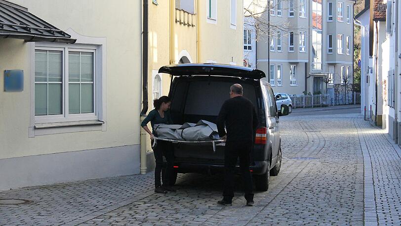 Bestatter tragen die Leiche des ermordeten Mitbewohners aus dem Haus. Bestatter tragen die Leiche des ermordeten Mitbewohners aus dem Haus.