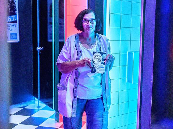 Helga Bauermann, Toilettenfrau, steht mit ihrem Buch in der Toilette der Disco "Stars" in Straubing. Foto: Armin Weigel