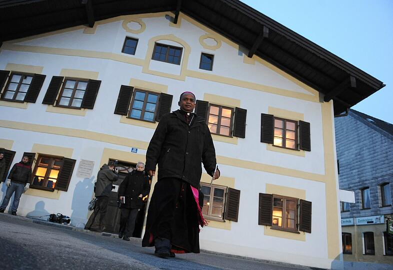 Vor dem Geburtshaus des Papstes steht ein Bischof. Er ist Mitglied einer Delegation aus Rom, die an einer Konferenz zum Weltkrankentag in Altötting teilnimmt und gestern Marktl besuchte.