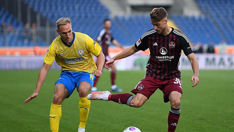 Nürnbergs Lukas Schleimer (r) spielt gegen Braunschweigs Florian Krüger.