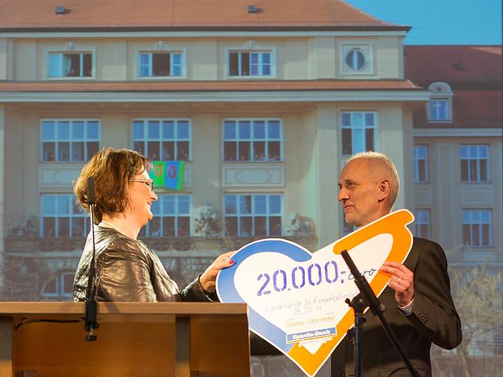 Christine Miedl, Direktorin Unternehmenskommunikation bei der Sparda- Bank München, überreicht
Sonderschulkonrektor Johannes Nauerz die Spende.