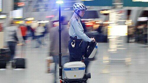 Polizistin mit Steh-Elektroroller auf dem Düsseldorfer Flughafen Polizistin mit Steh-Elektroroller auf dem Düsseldorfer Flughafen