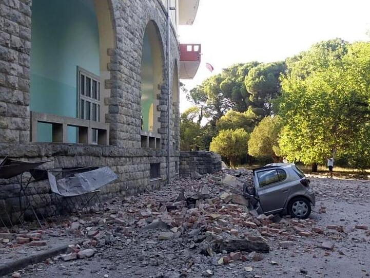 Ein beschädigtes Auto liegt nach einem Erdbeben unter den Trümmern eines Gebäudes in Tirana.
