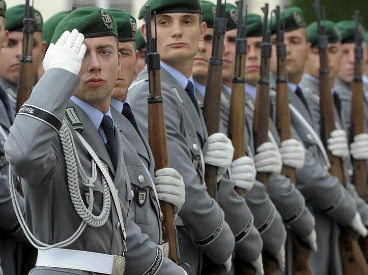 Soldaten der Ehrenformation der Bundeswehr grüßen vor dem Schloss Bellevue in Berlin (Archivfoto vom 03.08.2010)