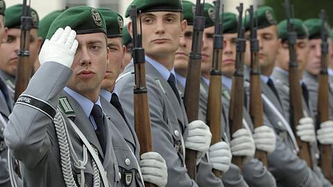 Soldaten der Ehrenformation der Bundeswehr grüßen vor dem Schloss Bellevue in Berlin (Archivfoto vom 03.08.2010)