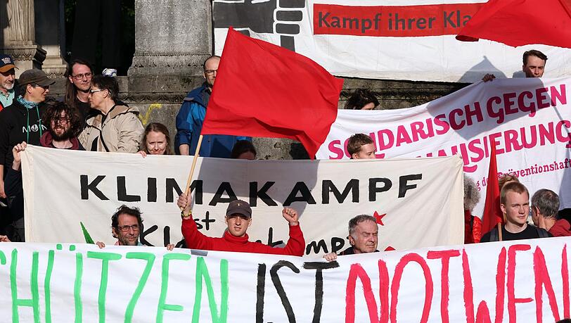 Menschen stehen bei einer Solidaritätskundgebung für die Letzte Generation vor dem Friedensengel.