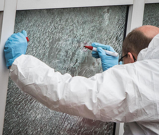 Ein Ermittler sichert an einem Flüchtlingsheim in Dreieich Spuren. Dort war am Montag (04.01.2016)bei einem Anschlag ein Bewohner verletzt worden.