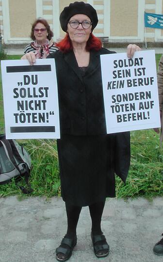 Eine Frau protestiert als Trauernde vor dem Schloss.