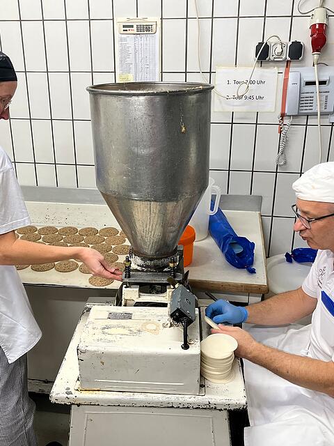 Mit einer Trittmaschine stellen Produktionsleiter Frank Schmahl und Stellvertreterin Lisa Zwickel Elisenlebkuchen her.