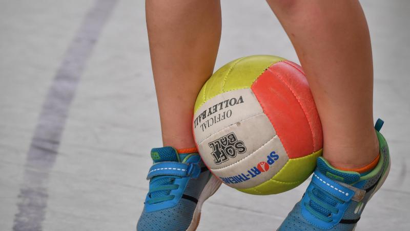 Ein Schulkind hüpft mit einem Ball zwischen den Beinen. Ein Schulkind hüpft mit einem Ball zwischen den Beinen.