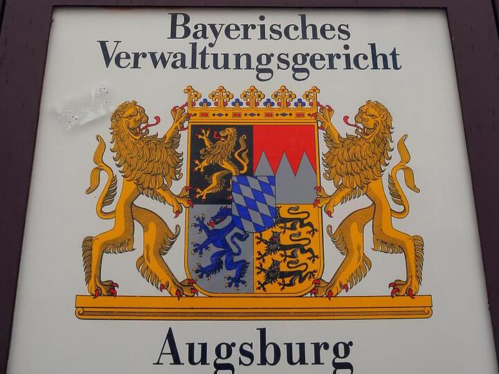 Ein Hinweisschild befindet sich vor dem Bayerischen Verwaltungsgericht Augsburg. Foto: Karl-Josef Hildenbrand/dpa/Archivbild