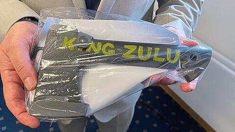 Ein LKA-Ermittler hält während der Pressekonferenz in München eine sichergestellte schwarze Axt mit der Aufschrift "King Zulu" in den Händen. Mit so einer Axt oder auch Peitschen haben die Bosse der "Black Axe" aufmüpfige Mitglieder auf Linie gebracht und eingeschüchtert.  dpa