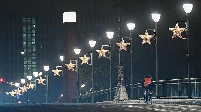 Ein Radfahrer ist nach einem Wintereinbruch in der Nacht auf der Alten Brücke in Frankfurt unterwegs.