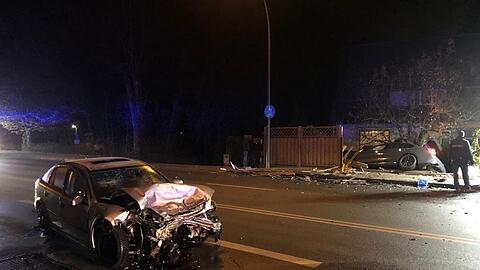 Ein Auto kracht durch einen Zaun, das andere bleibt auf der Straße stehen. An beiden Wagen entsteht Totalschaden.