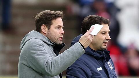 Schau mal, Agi: Sportchef Werner (l.) hat in Essen einen Zettel für Coach Giannikis dabei, 1860 siegt mit 3:0.