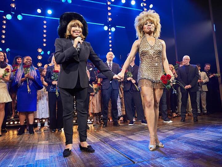 Tina Turner (l) und Kristina Love mit Ensemble stehen nach der Deutschland-Premiere des Musicals "Tina" auf der Bühne. Foto: Georg Wendt