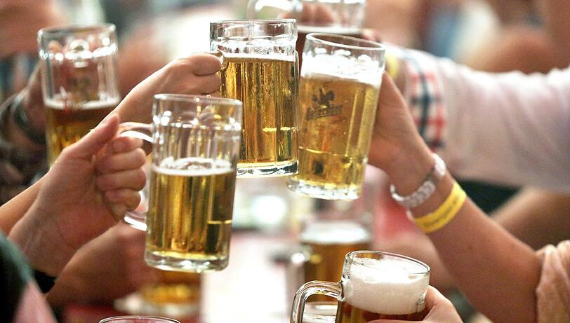 Die Tassen hoch: Besucher eines Volksfestes in der Lutherstadt Eisleben.
