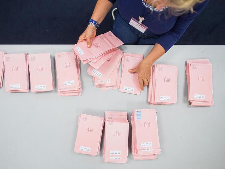 Wahlhelfer sortieren rote Wahlbriefe. Foto: picture alliance/Rolf Vennenbernd/dpa/Symbolbild