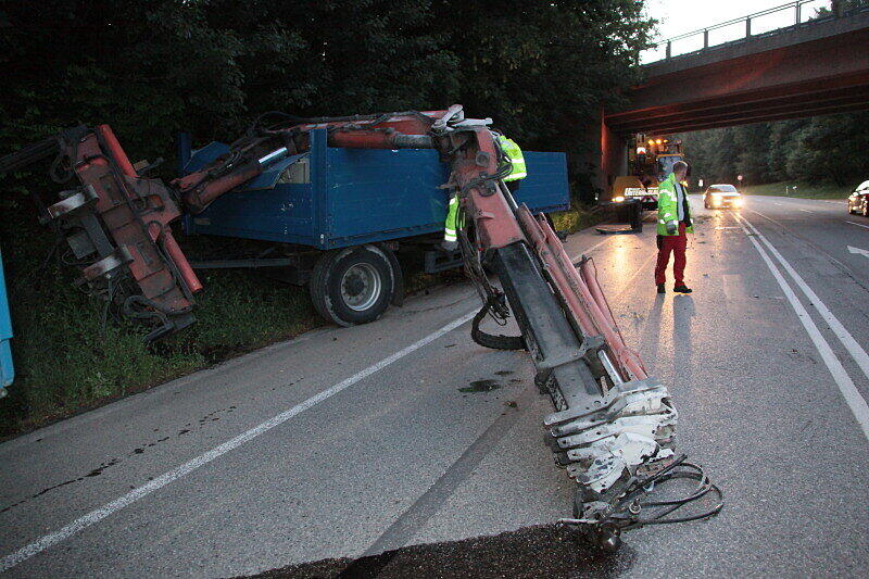 Bei Mühldorf ist ein Lkw mit Ladekran gegen eine Brücke gekracht. Der Kran wurde dabei aus der Verankerung gerissen und landete auf der Straße. Die Bilder.