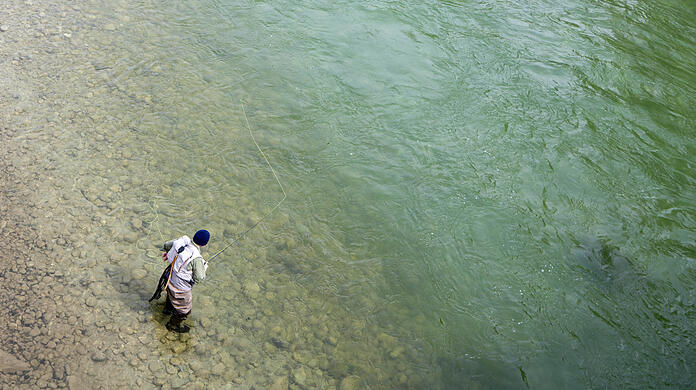 Ein Angler steht am Isarufer. Nicht alle haben dazu auch eineBerechtigung – und schaden den Fischen.