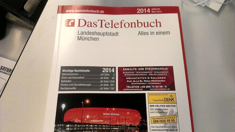 Das Münchner Telefonbuch für 2014 - darauf prangt die hell erleuchtete Allianz Arena...