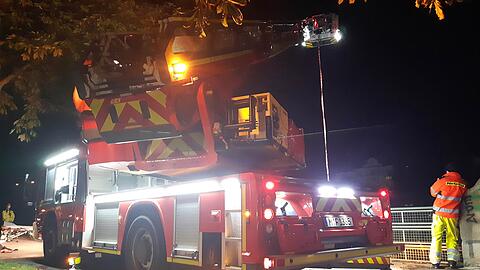 Die Feuerwehrleute hoben die unverletzte, aber unterkühlte Frau mit Hilfe der Drehleiter vom Flussbett auf die Straße.