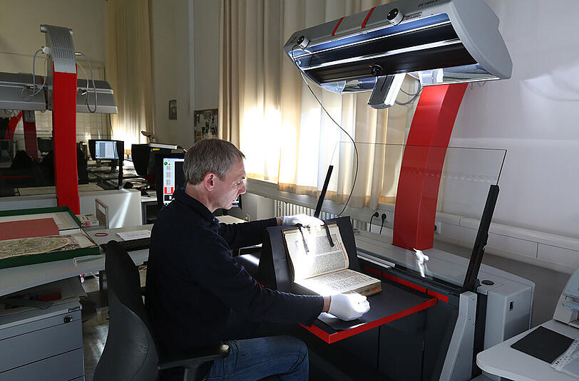 Mit einem Spezialscanner wird im Münchner Digitalisierungszentrum ein altes Werk digitalisiert.