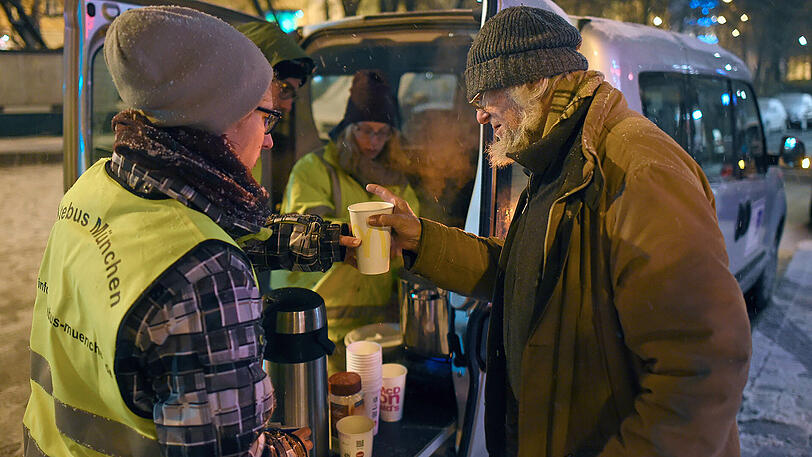 Freiwillige Helfer des Vereins "Kältebus München" verteilen in München warmes Essen und Getränke an Obdachlose.