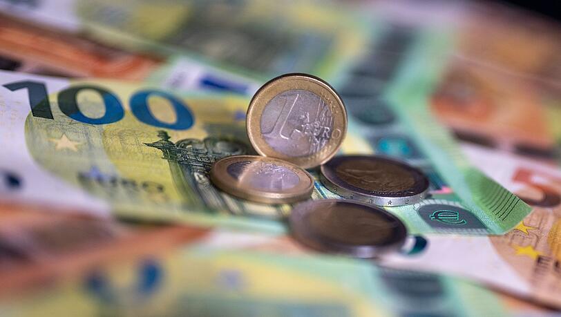 Geldscheine mit dem Wert von 100 und 50 Euro und Münzen liegen auf einem Tisch.
