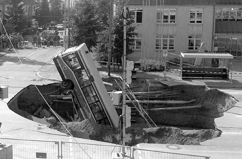 Plötzlich hat sich mitten in München die Erde aufgetan: Der verunglückte Bus ragt aus dem Krater.