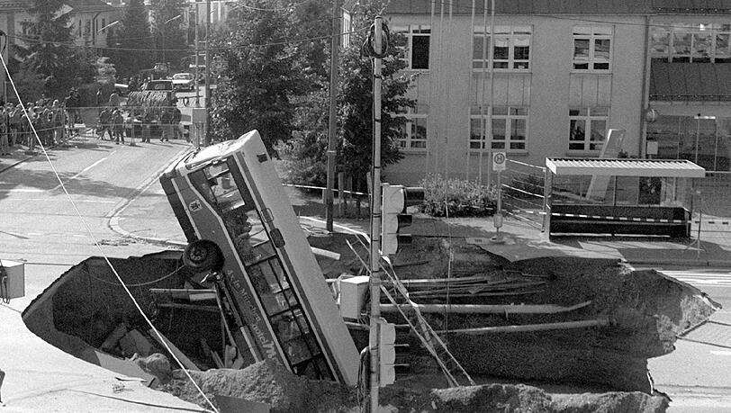 Plötzlich hat sich mitten in München die Erde aufgetan: Der verunglückte Bus ragt aus dem Krater. Plötzlich hat sich mitten in München die Erde aufgetan: Der verunglückte Bus ragt aus dem Krater.