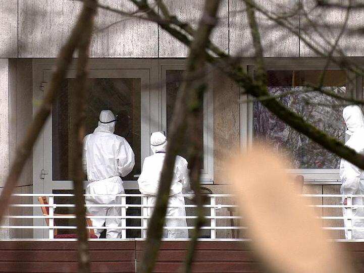 Pflegekräfte in Schutzkleidung vor einem Altenheim.