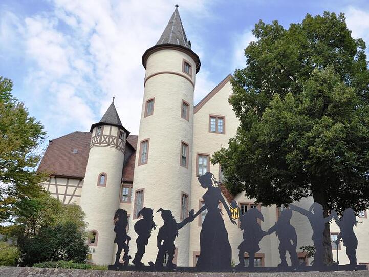 Vor dem Schloss in Lohr am Main steht eine Abbildung von Schneewittchen und den Zwergen. Foto: Barbara Grimm/Spessartmuseum