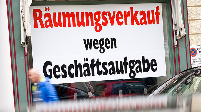 Ein Schild mit der Aufschrift "Räumungsverkauf wegen Geschäftsaufgabe" hängt im Schaufenster eines Ladengeschäfts in der Münchner Innenstadt.