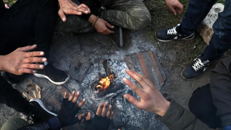 Migranten sitzen nahe der türkisch-griechischen Grenze um ein Lagerfeuer herum und versuchen, sich zu wärmen. Migranten sitzen nahe der türkisch-griechischen Grenze um ein Lagerfeuer herum und versuchen, sich zu wärmen.