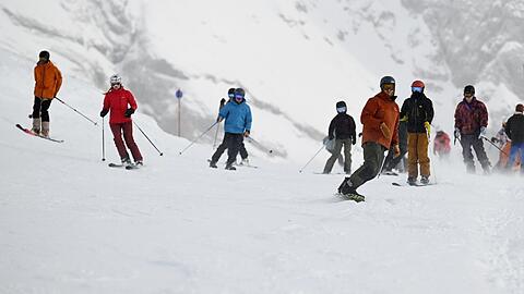 Skifahrer sind beim Skisaisonstart an der Zugspitze auf der Piste unterwegs.