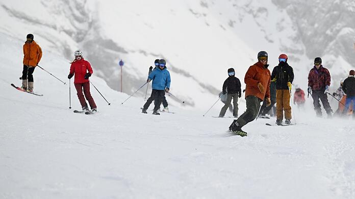 Skifahrer sind beim Skisaisonstart an der Zugspitze auf der Piste unterwegs.