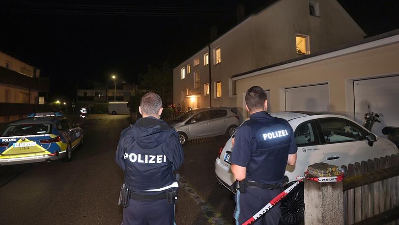 Polizisten stehen vor dem Haus in Langweid, in dem drei Menschen erschossen wurden. Foto: Karl-Josef Hildenbrand/dpa