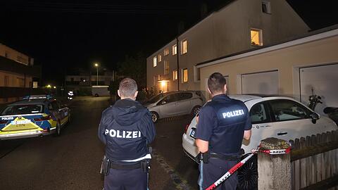 Polizisten stehen vor dem Haus in Langweid, in dem drei Menschen erschossen wurden. Foto: Karl-Josef Hildenbrand/dpa