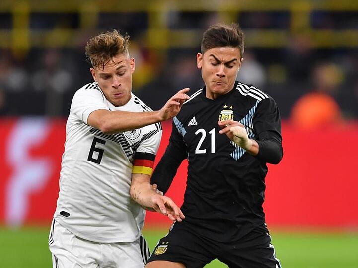 Joshua Kimmich aus Deutschland kämpft mit Paulo Dybala (r) aus Argentinien um den Ball. Foto: Marius Becker/dpa