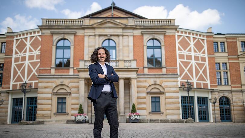 Der österreichische Regisseur Valentin Schwarz steht vor dem Festspielhaus.