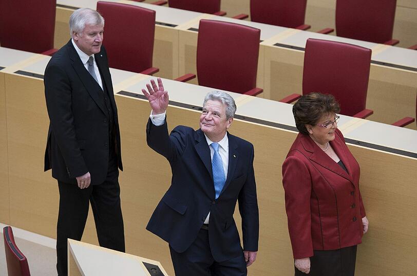 Bundespraesident Joachim Gauck (M.) am Dienstag im Plenarsaal im Landtag bei seinem Antrittsbesuch. Zwischen Ministerpraesident Horst Seehofer (CSU) und Landtagspraesidentin Barbara Stamm (CSU) winkt er Zuschauern zu.