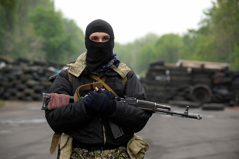 Ein bewaffneter pro-russischer Aktivist steht in der Nähe von Slavyansk an einer Kontrollstelle Wache.
